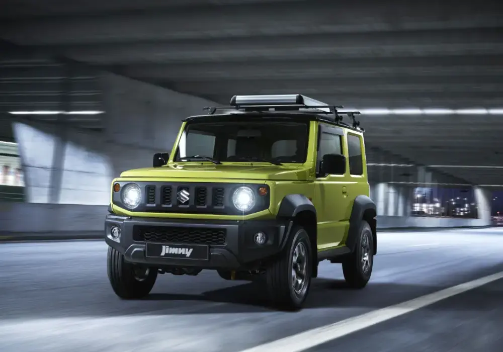 Suzuki Jimny amarillo en una carretera urbana